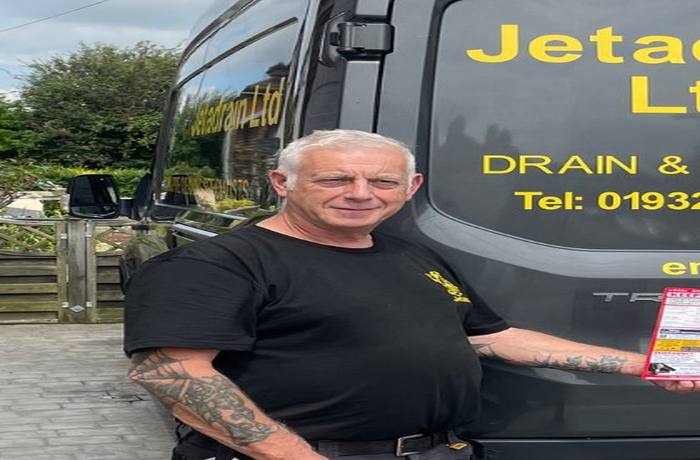 Keith from Jetadrain Ltd holding a Keep Me Card in front of his branded drain specialist van
